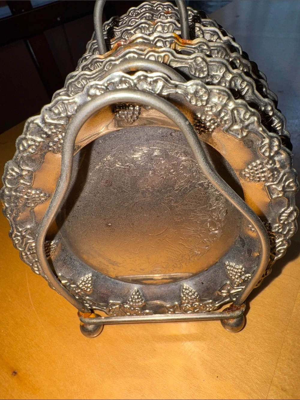 six vintage silver-plated drink coasters with ornate, embossed floral